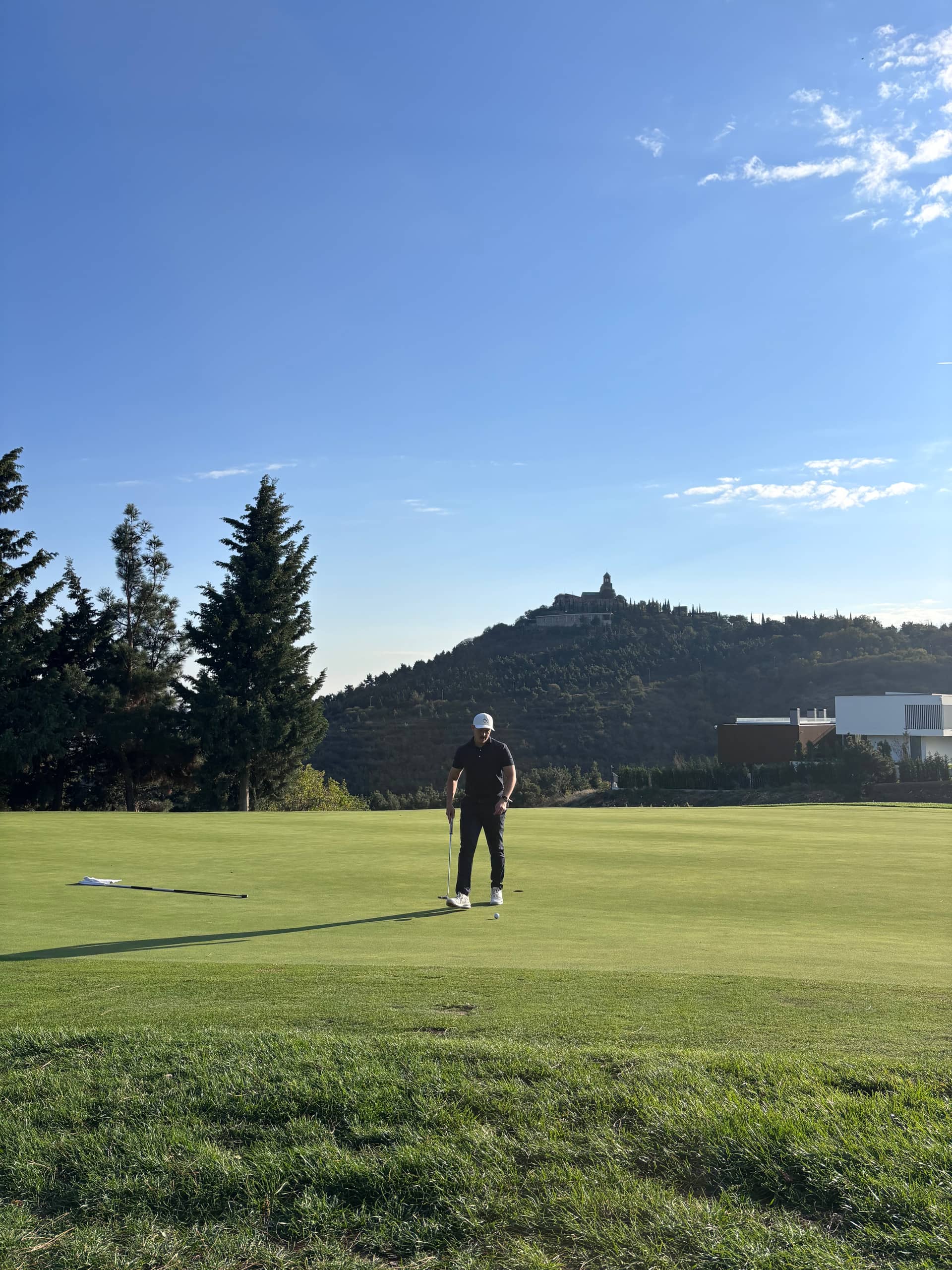 Huw Williams on a resort course with a hillside chapel behind