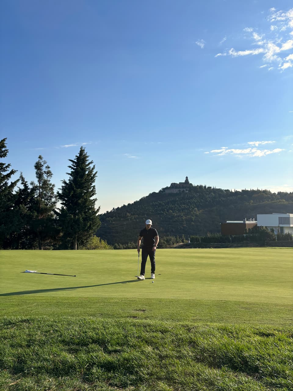 Huw Williams on a resort course with a hillside chapel behind